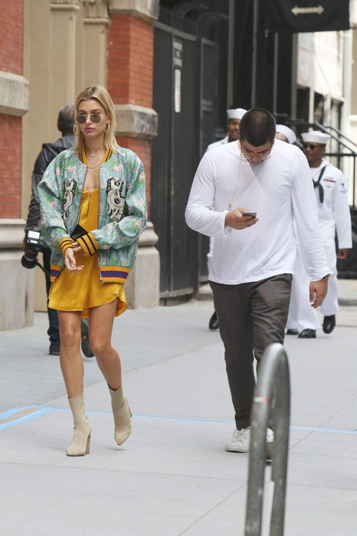 Hailey Baldwin con vestido amarillo y bomber estampada