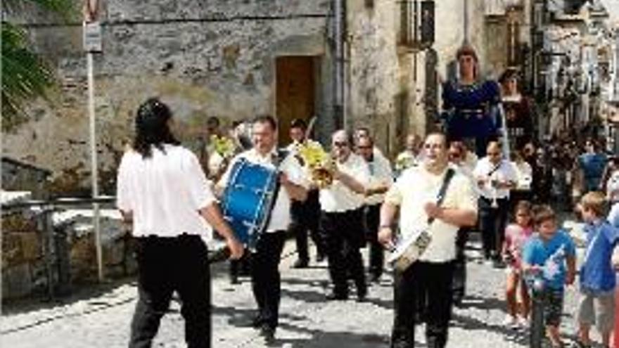 La comitiva, amb els gegants i la banda de música, passejant.