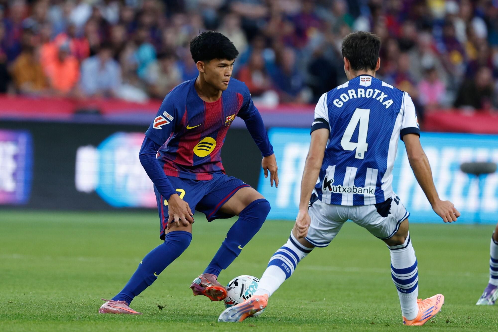 Barcelona's Dro Fernandez, left, dribbles the ball past Real Sociedad's Jon Gorrotxategi during a Spanish La Liga soccer match between FC Barcelona and Real Sociedad at the Lluis Companys Olympic Stadium in Barcelona, Spain, Sunday, Sept. 28, 2025. (AP Photo/Joan Monfort). EDITORIAL USE ONLY/ONLY ITALY AND SPAIN
