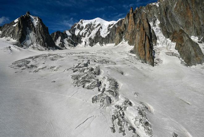 Climbers walk on the Glacier du Geant next to the Mont Blanc peak (C, top) on July 20, 2019, in the Mont Blanc range over the Chamonix Valley, in the French Alps.