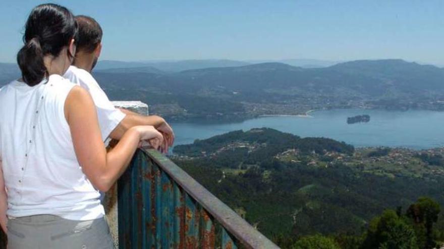 Una pareja observa la ría desde el mirador de la torre de vigilancia forestal de Cotorredondo. // Gustavo Santos