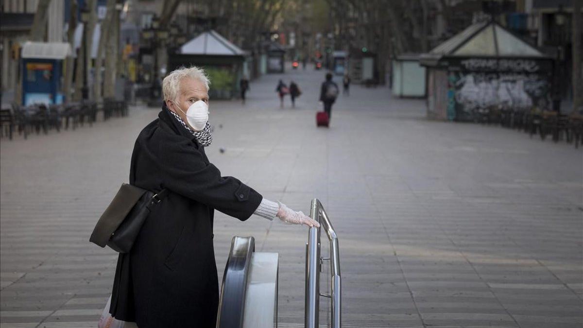 Barcelona coronavirus. Un hombre con mascarilla en la Rambla vacía