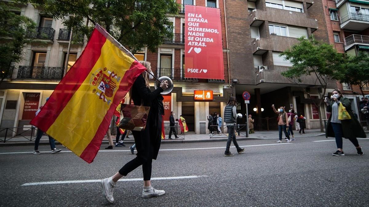 Manifestación ante la sede del PSOE, protegida por la Policía Nacional, por la gestión de la crisis sanitaria, el sábado 16 de mayo