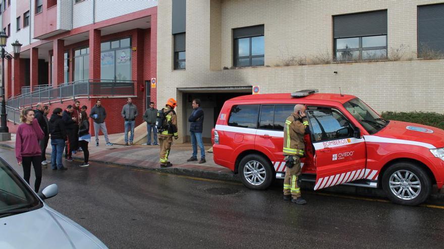 Vecinos junto a bomberos esta mañana a la entrada del garaje.