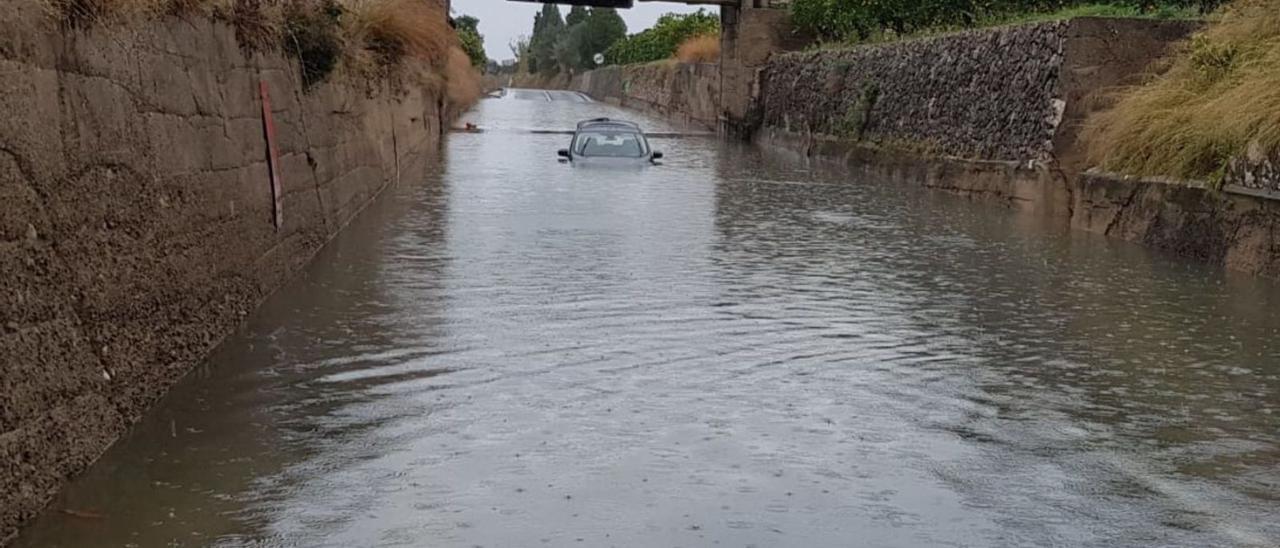El badén inundable de Bellreguard, con agua y un coche atrapado en el centro. | LEVANTE-EMV