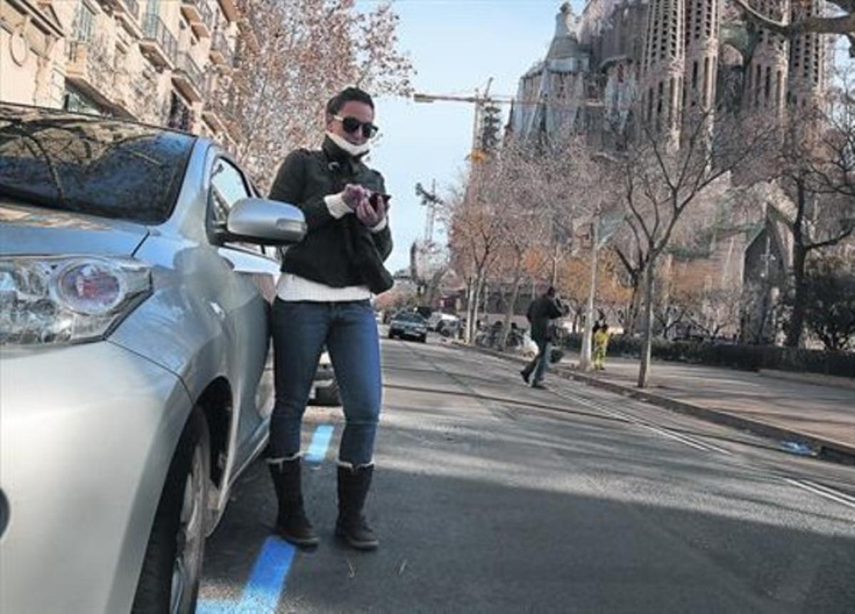 Una noia fa servir el mòbil, divendres, a la zona blava de pagament intel·ligent al carrer de Provença, davant la Sagrada Família. Una noia fa servir el mòbil, divendres, a la zona blava de pagament intel·ligent al carrer de Provença, davant la Sagrada Família.
