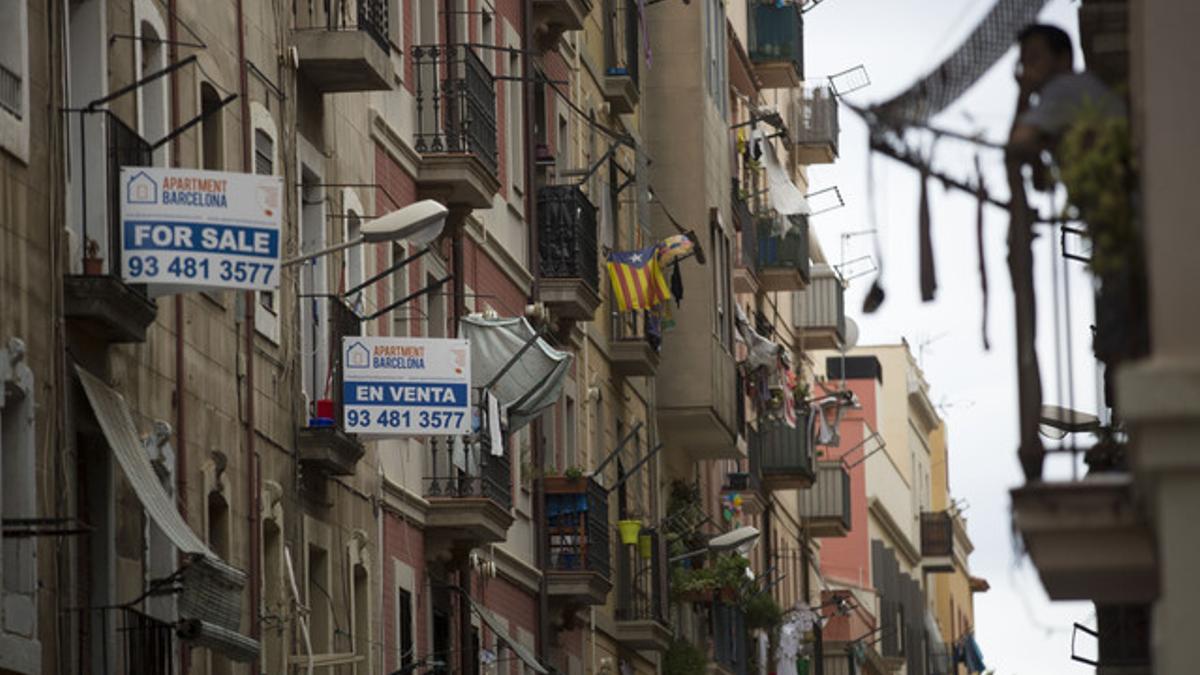 Anuncios de venta de pisos en castellano e inglés en una calle de la Barceloneta, este miércoles.