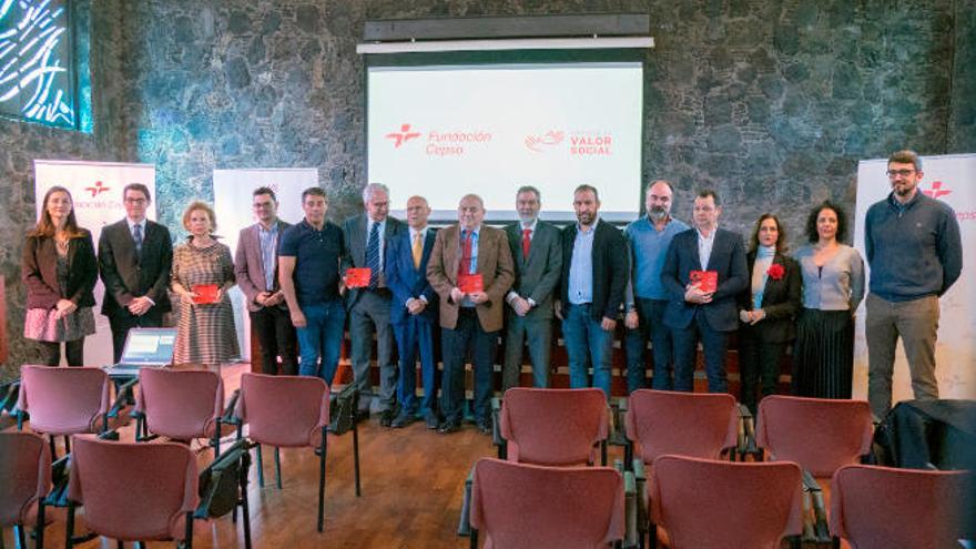 Los representantes de los cuatro proyectos ganadores, numerados y con las cajas rojas que recibieron, junto a los miembros del jurado y los responsables de la Fundación Cepsa.