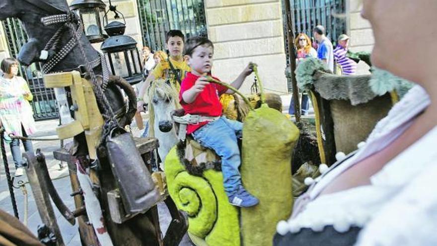 Un niño monta en los burros del mercado, en los que se puede dar un paseo por Gijón.  / ángel gonzález