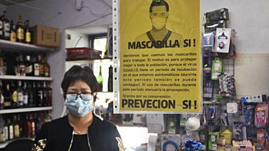 Una dependienta de un local de Vistabella, en Murcia, con mascarilla.