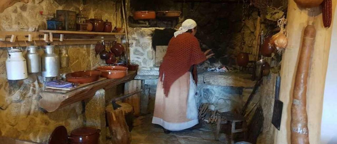 La mujer de la casa muestra cómo se enciende la lareira. // FdV