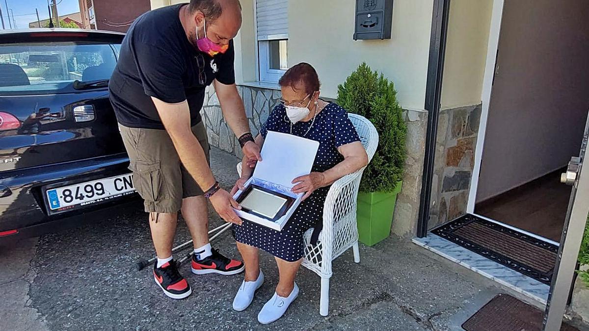 Angélica Martínez recibe su placa de manos de Santos Romero, presidente de “Camarzana Viva”. | C. G. R.