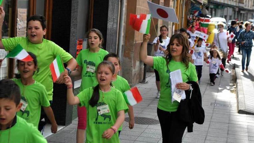 Arriba, desfile olímpico por Trevías; al lado, juegos en el colegio; abajo, Paula Villamaña coloca la llama olímpica tras transportarla.