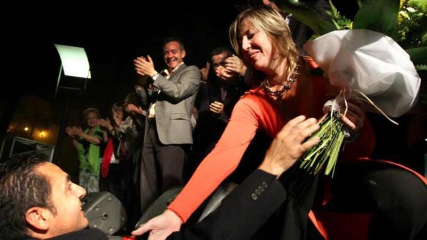 El marido de la candidata Gema Amor, entregándole un ramo de flores tras su intevención en el cierre de campaña.