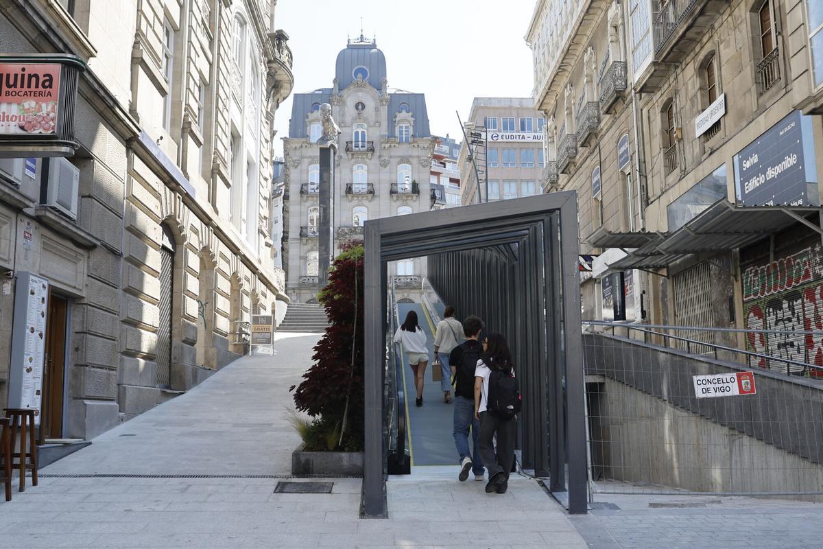 Personas utilizando la rampa mecánica de la calle Carral, que completó la humanizacion de Porta do Sol