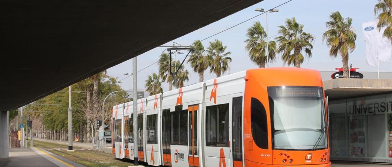 Un TRAM realiza su parada frente a la Universidad de Alicante.