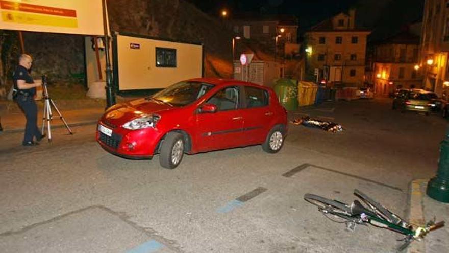 El cuerpo del fallecido, al fondo, y la bicicleta y el turismo implicados en el siniestro.