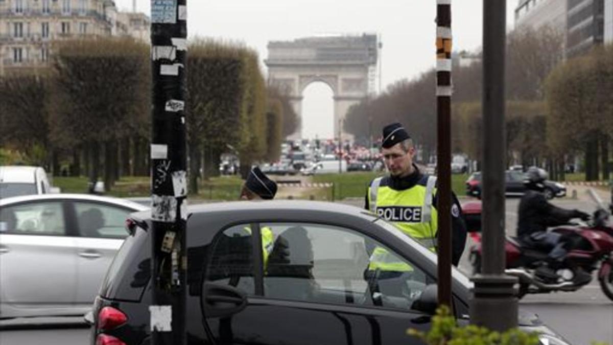 Control policial de vehículos en el centro de París, cerca del Arco del Triunfo.