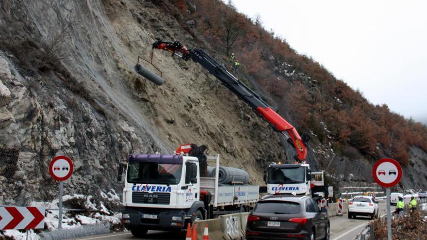 Operaris instal·lant la malla al talús