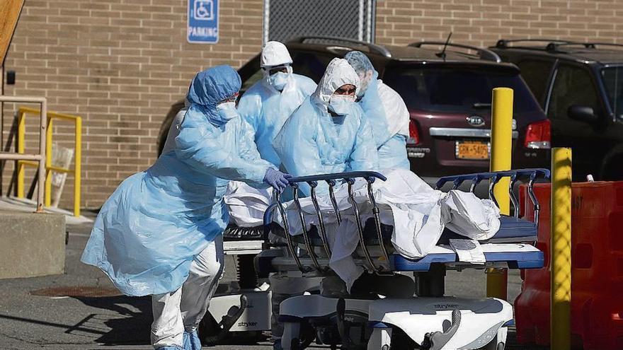 Sanitarios de un hospital de Nueva York sacan cuerpos a la calle. // Reuters