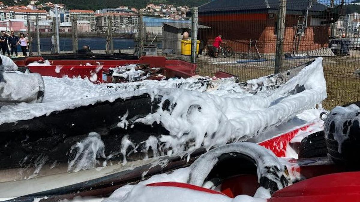 Restos de la embarcación que ardió esta mañana en el puerto de Ribeira