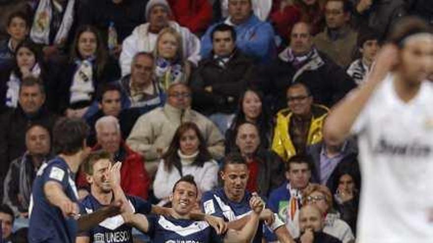 Los malaguistas celebran el golazo de Cazorla en el tiempo de descuento en el Bernabéu.