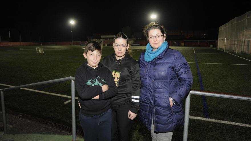 Dos de las madres que protestan por el trato recibido, con uno de los jugadores, ayer, en Outeiriño.