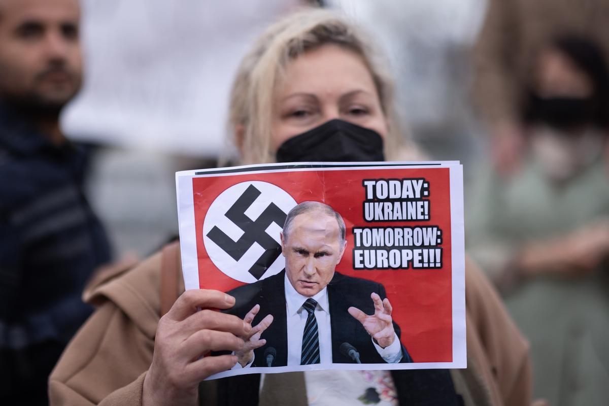 Una manifestante con un cartel de Putin