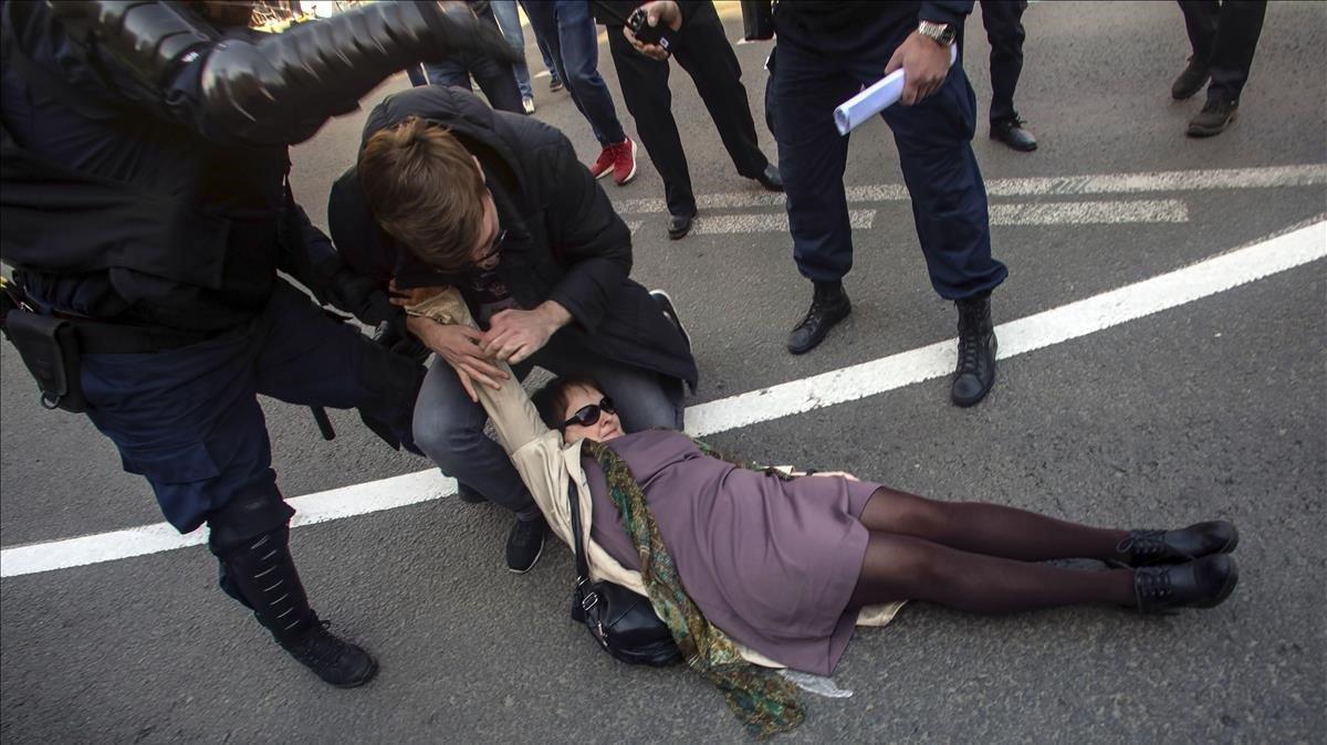 Un agente de la policía antidisturbios intenta detener a una mujer mientras la otra la defiende durante un mitin en San Petersburgo, Rusia.