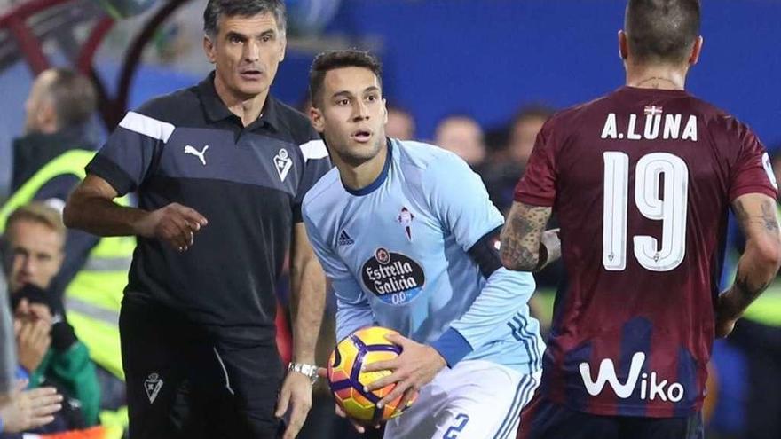 Hugo Mallo se dispone a sacar de banda ante José Luis Mendilibar, técnico del Eibar, y Luna durante el partido disputado el sábado en Ipurua. // LOF