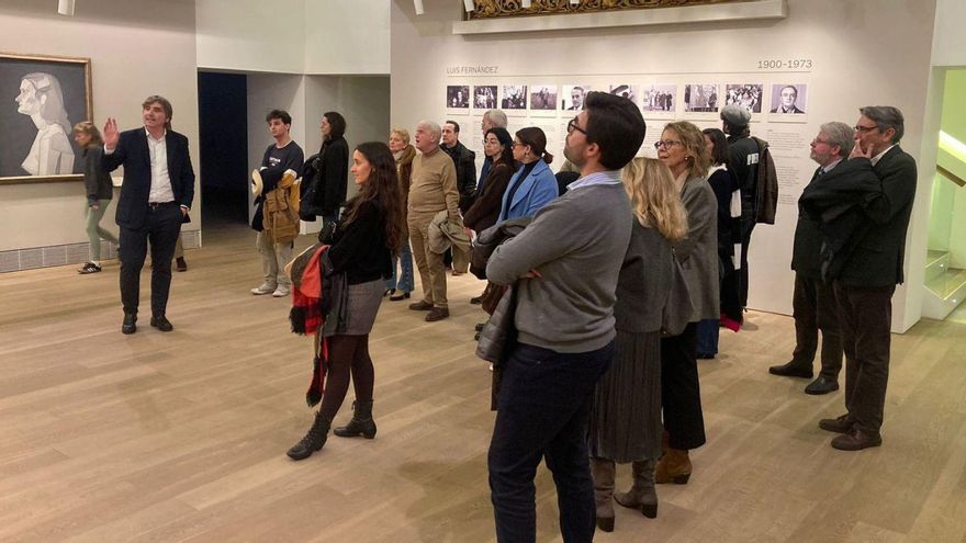 Alfonso Palacio, a la izquierda, guía al grupo formado por Amigos de la Ópera, Oviedo Filarmonía y la Filarmónica de Gijón por la exposición de Luis Fernández en el Bellas Artes.