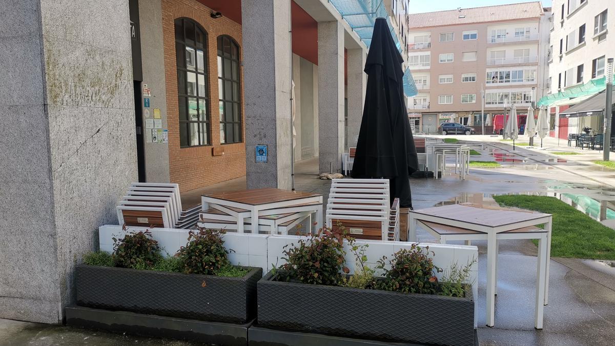 La terraza recogida de un establecimiento al lado de un soportal en la Praza Massó de Bueu.