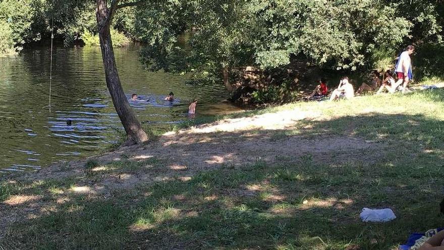 Visitantes disfrutan de una calurosa jornada en la playa fluvial de Cira.