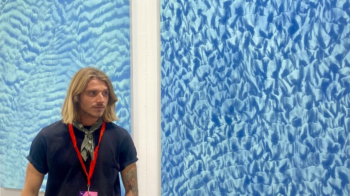 El joven artista Iyán Castaño, ante dos de sus obras, en la Feria de Arte Contemporáneo Estampa de Madrid.