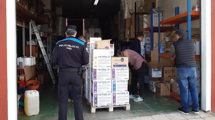 Agentes de la Policía Local incautando 40.000 guantes de nitrilo en el barrio de Teis en Vigo. // FDV