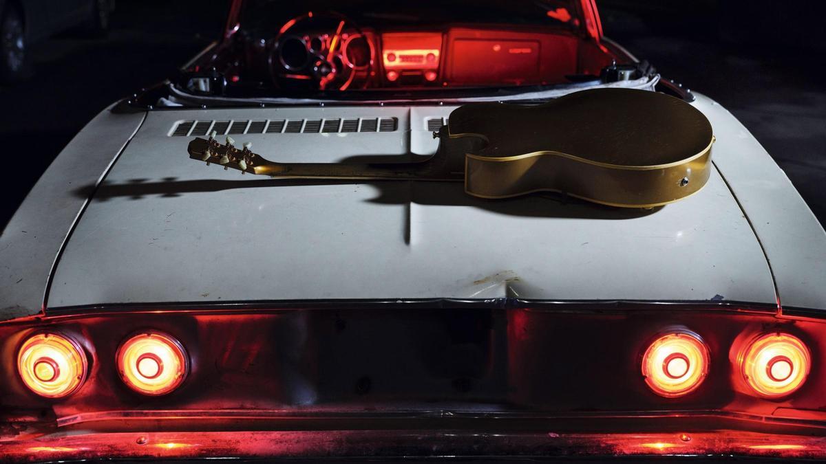 Una guitarra —instrumento directamente ligado a la música de Bryan Adams— sobre un capó de un coche conforma la imagen que cierra el calendario.
