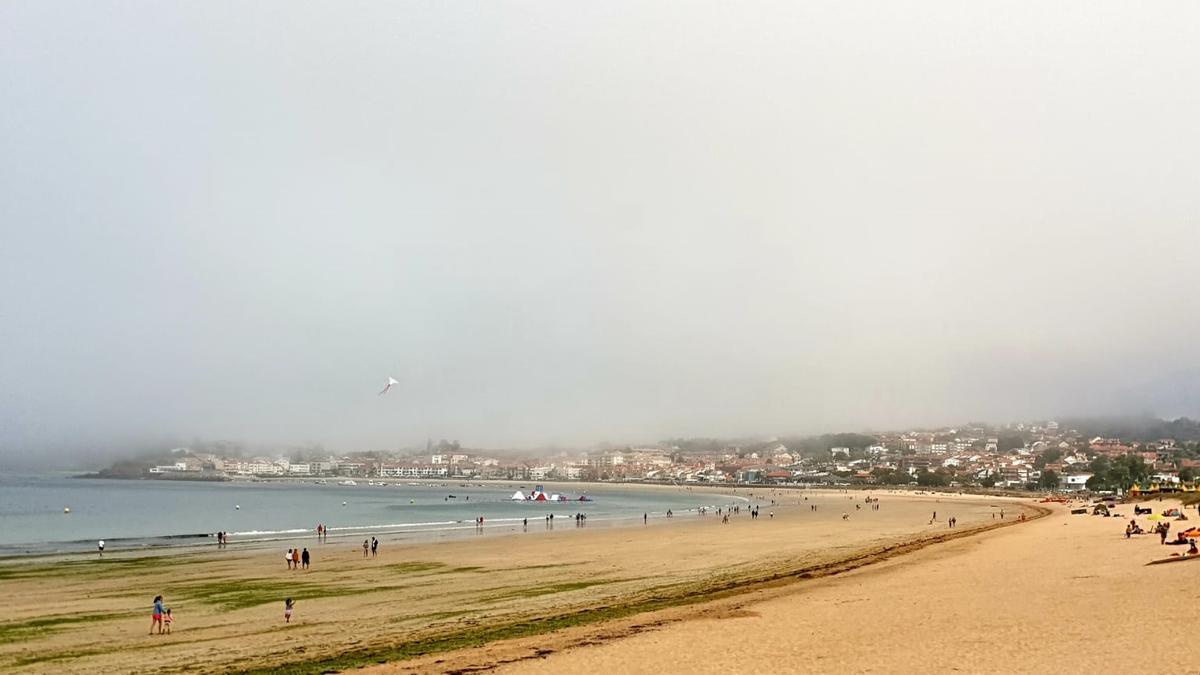 Vecinos y turistas recorren Praia América en una mañana nublada