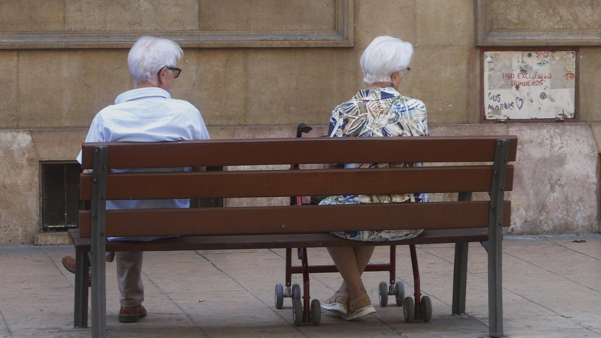 Una pareja de ancianos sentada en un banco de la ciudad de Zaragoza.