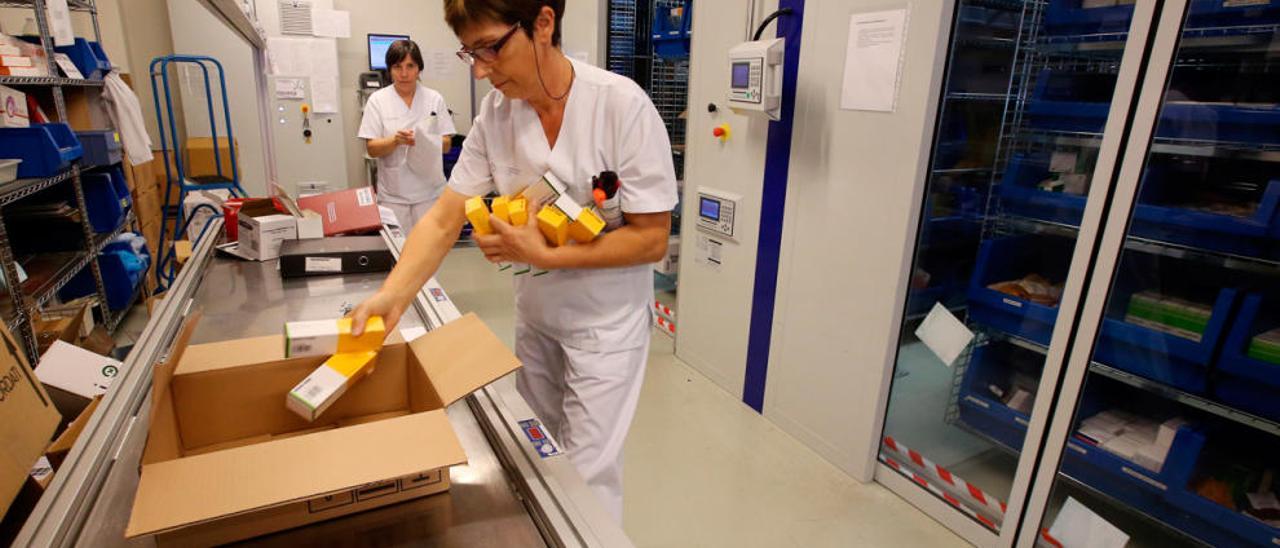 Profesionales del servicio introduciendo medicamentos en el almacén robotizado. // Marta G. Brea