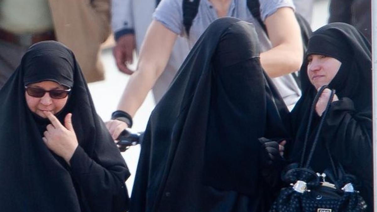 Una mujer con niqab (centro) junto a otras dos musulmanas con velo en Lleida.