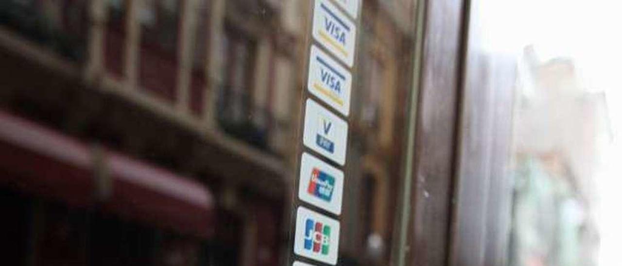 Identificación en la puerta de un comercio local que lo acredita como colaborador de la renta social.