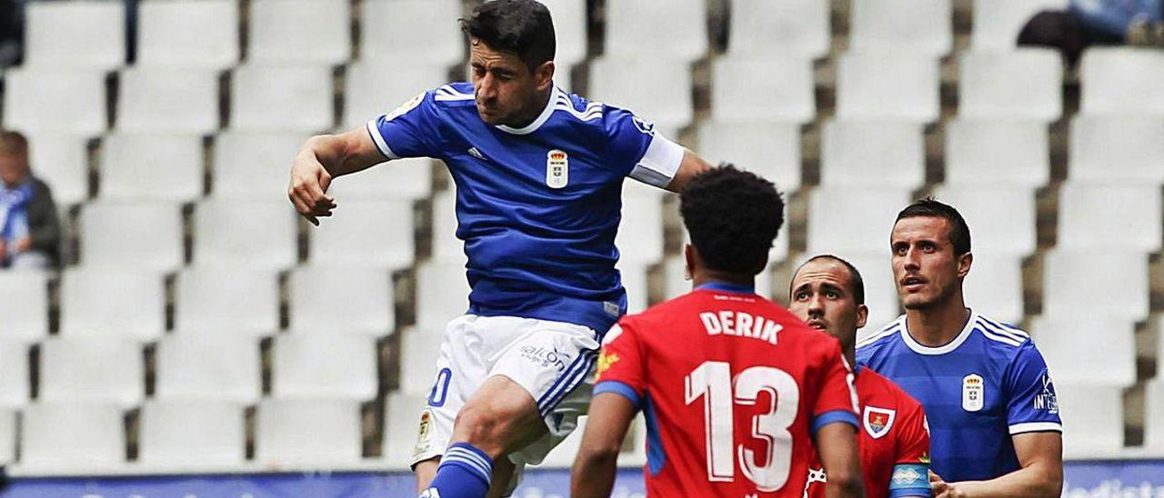 Berjón salta ante los jugadores del Numancia Derik y Unai Medina, con Christian Fernández a la derecha.