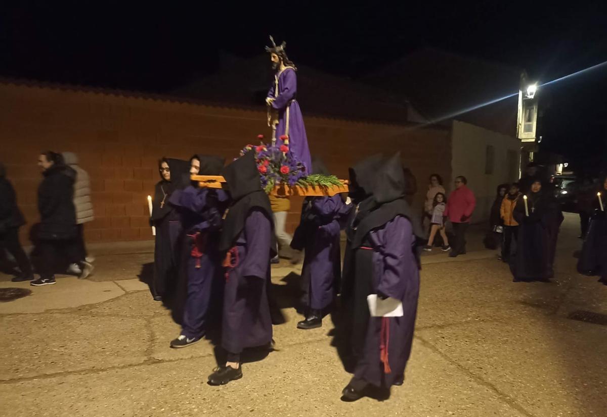 Vecinos y cofrades acompañan a la imagen de Cristo en el recorrido por las calles