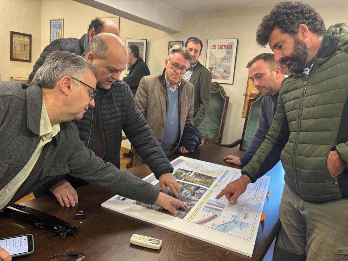 Personas observando el proyecto de la nueva infraestructura de regulación en Valverde de la Vera.