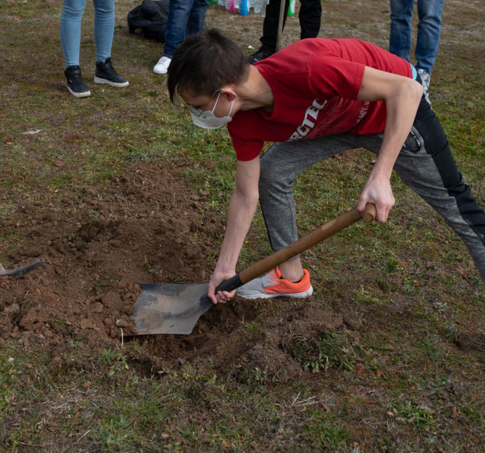 Un estudiante prepara el terreno para plantar.