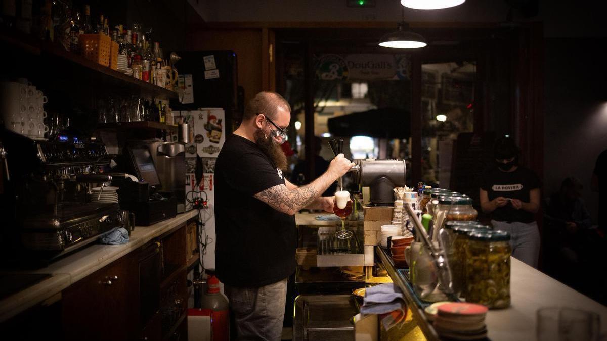 Un camarero sirve una cerveza.