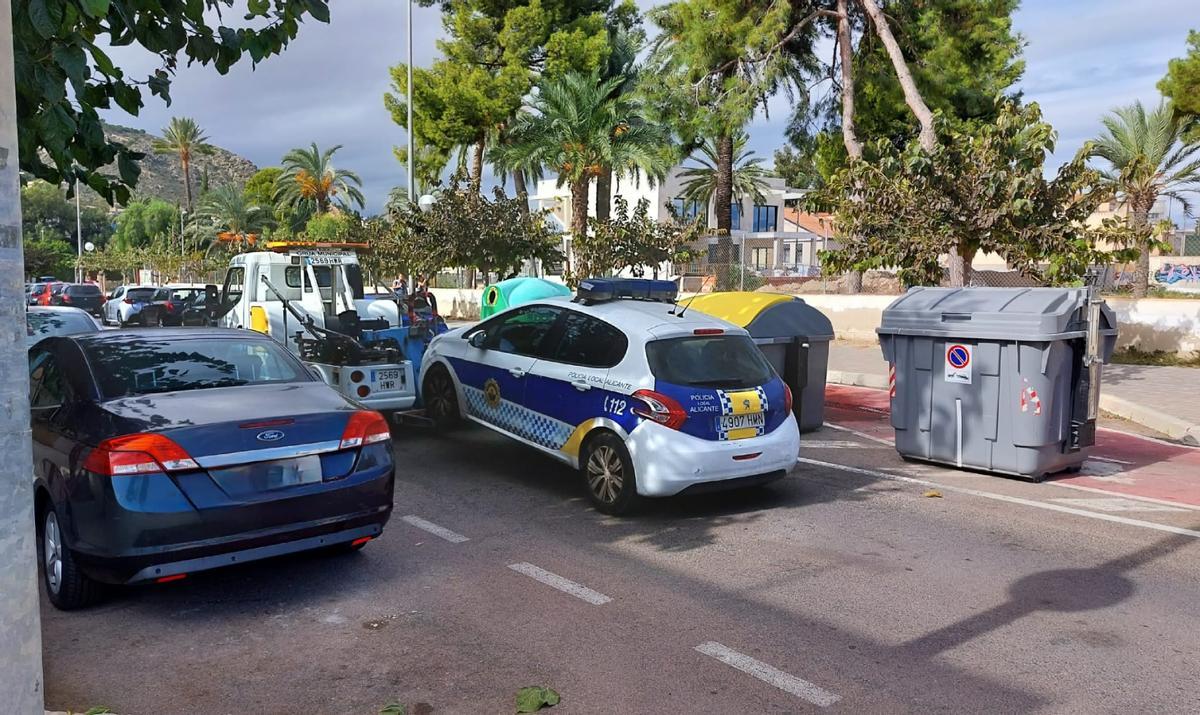 Una grúa retira un vehículo de la Policía Local, en una imagen facilitada por Compromís