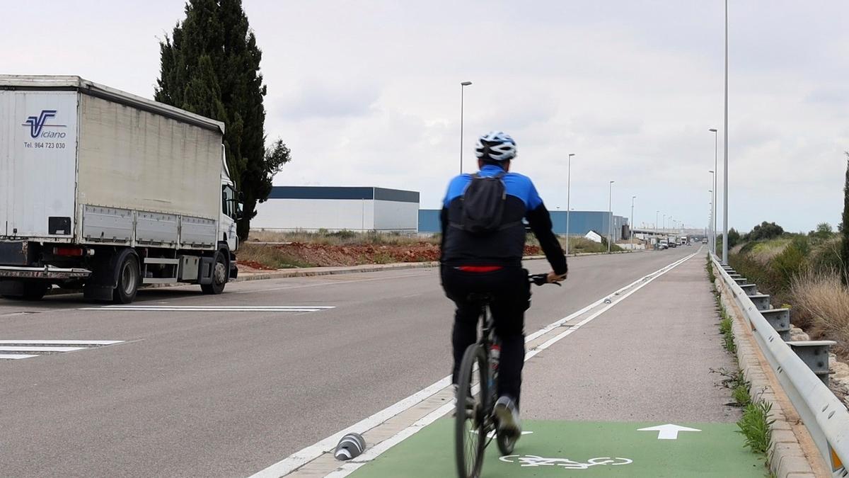 Un hombre circula con su bici por el carril habilitado en una carretera de Onda.