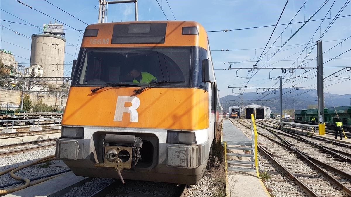 Un operario del servicio de limpieza desinfecta la cabina del maquinista de un tren de Rodalies en Montcada-Bifurcació.