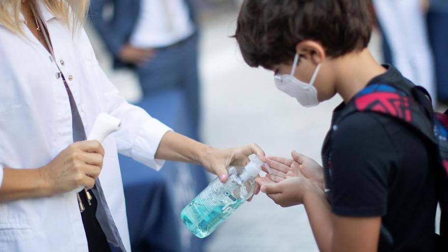 Un nen es desinfecta les mans a l&#039;entrada del col·legi privat internacional American School of Barcelona